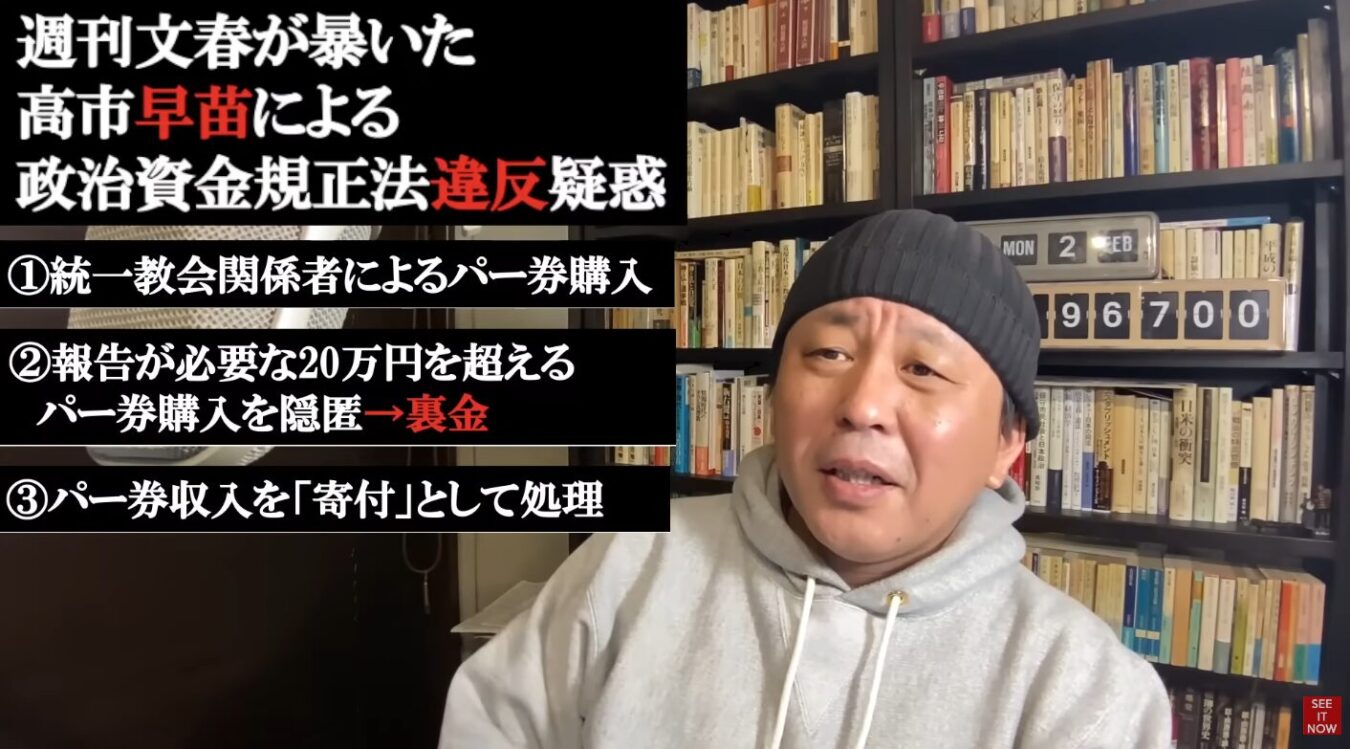 自身の著作と思われる本棚を背景に、高市早苗氏の政治資金規正法違反疑惑を指摘するテキストが重ねられた菅野完の動画配信のスクリーンショット。