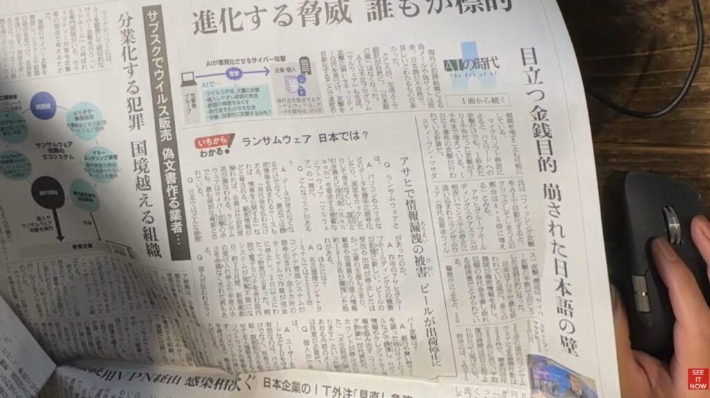 AIを活用したサイバー犯罪の脅威や、ランサムウェアの仕組みについて解説する日本の新聞記事の紙面。