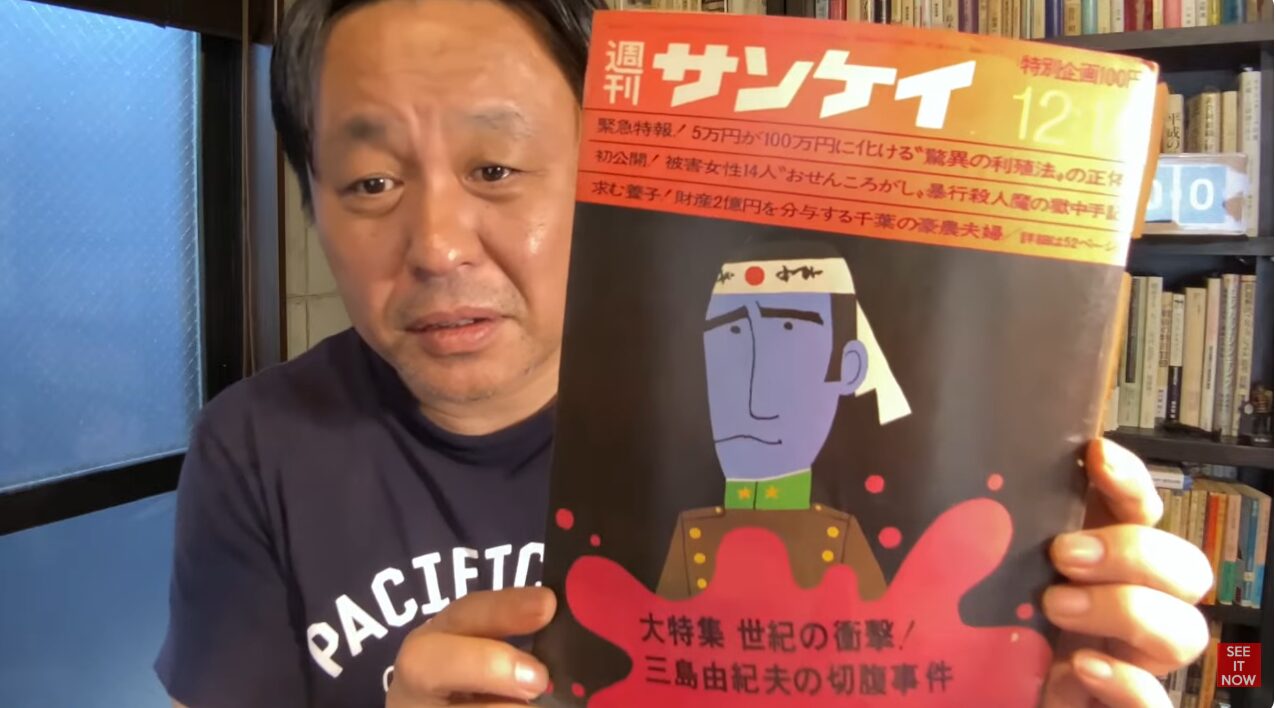 菅野完が週刊サンケイを手に持ち、表紙に掲載された三島由紀夫の切腹事件を大特集する過激な見出しやイラストを見せている様子。