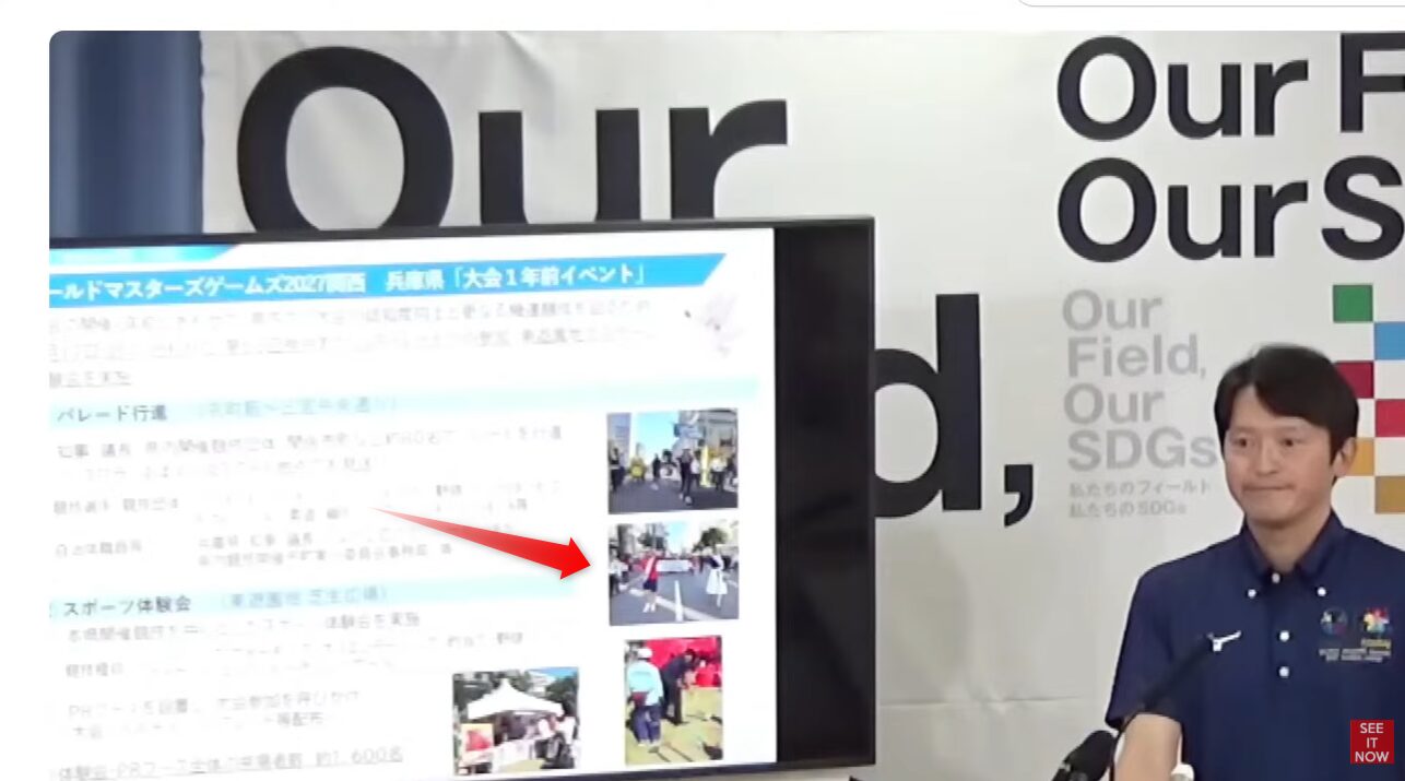 ワールドマスターズゲームズ2027関西の大会1年前イベントを紹介する登壇者と、パレードやスポーツ体験会の様子を示すモニター画面。
