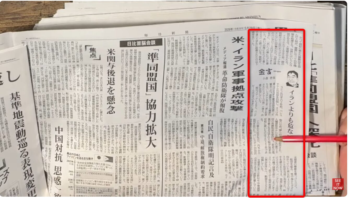 新聞紙面で、赤い枠で囲まれたコラム欄を赤いペンで指し示している様子。