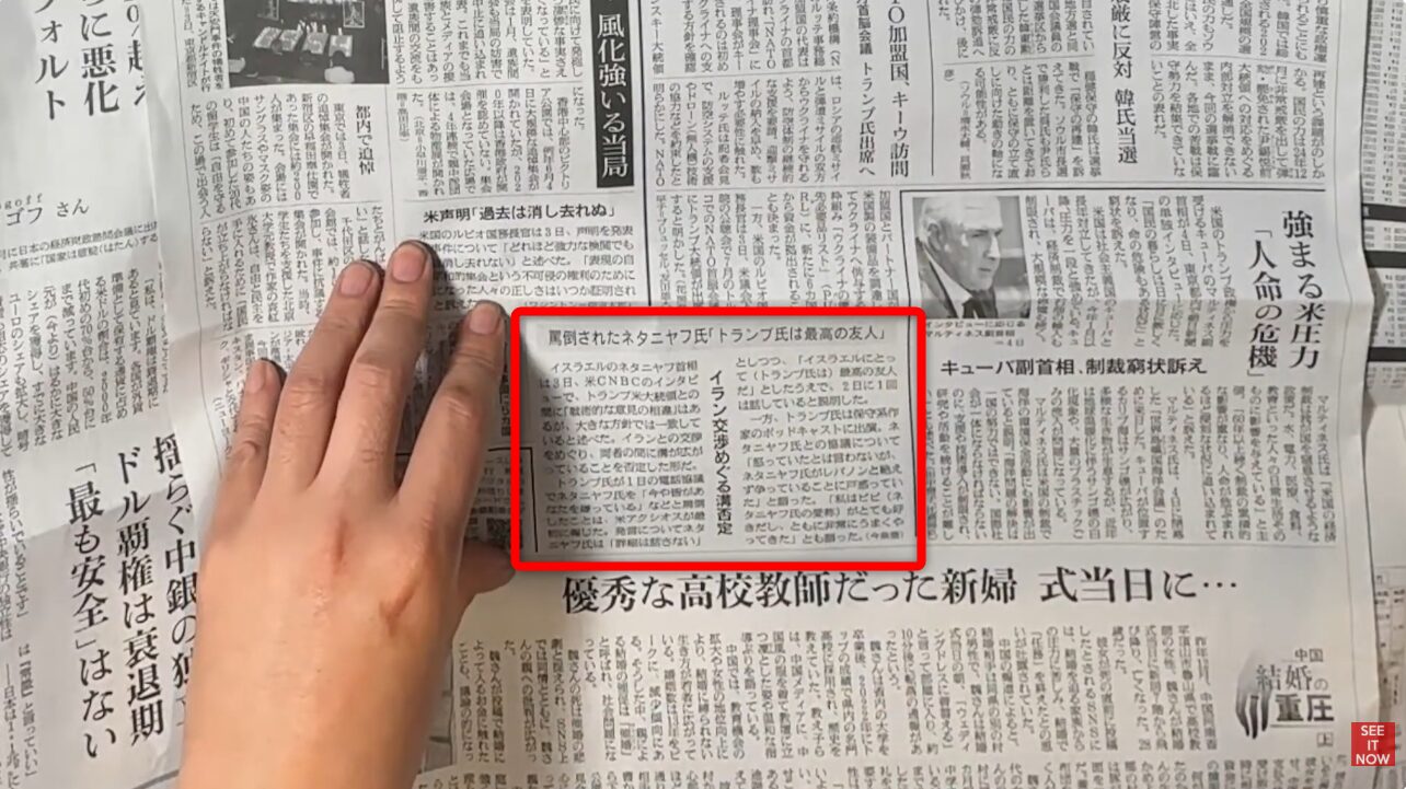 指で押さえられた新聞記事の一部。ネタニヤフ首相がトランプ氏との関係について言及した内容。