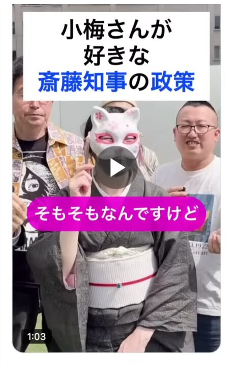 狐の面を被った着物姿の女性を中心に、男性二人が並ぶ動画サムネイル。小梅さんが好きな斎藤知事の政策というタイトルとそもそもなんですけどというテロップが表示されている。