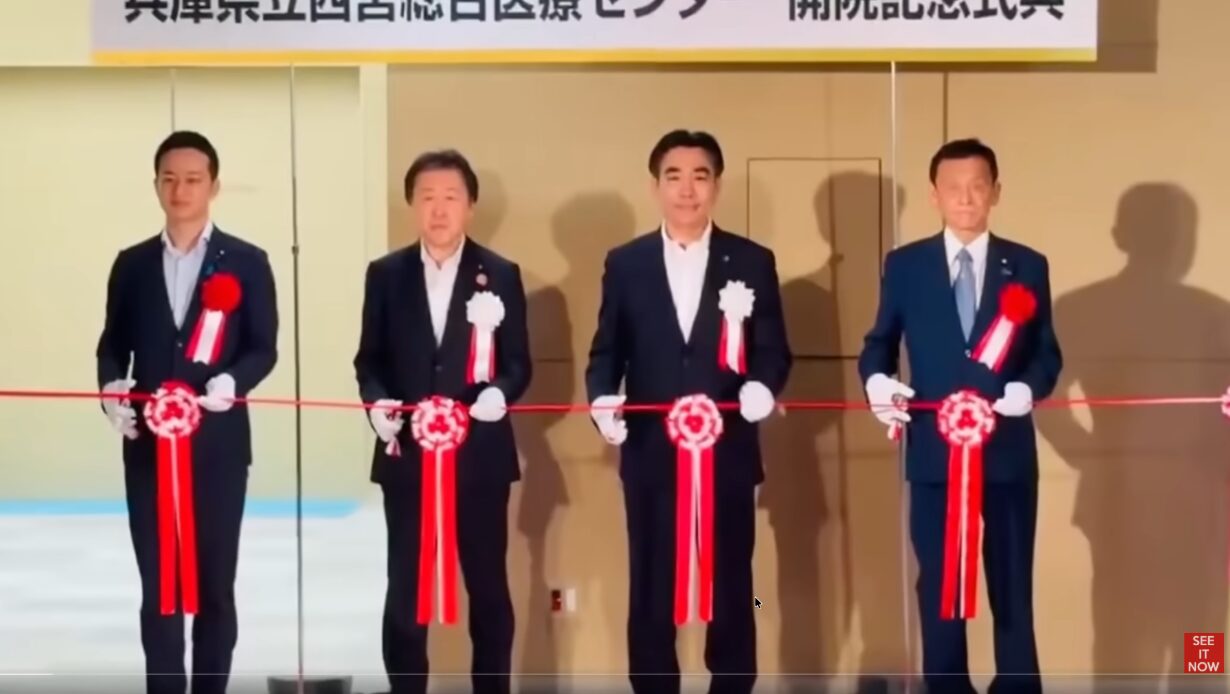 兵庫県立西宮総合医療センターの開院記念式典にて、スーツ姿の男性4人が並んでテープカットを行う。