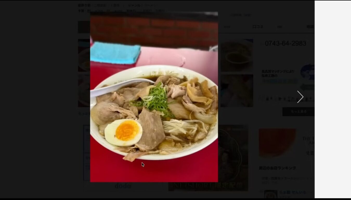 チャーシュー、煮卵、メンマ、刻みネギがトッピングされた醤油ベースのラーメン。白い丼に盛り付けられている。
