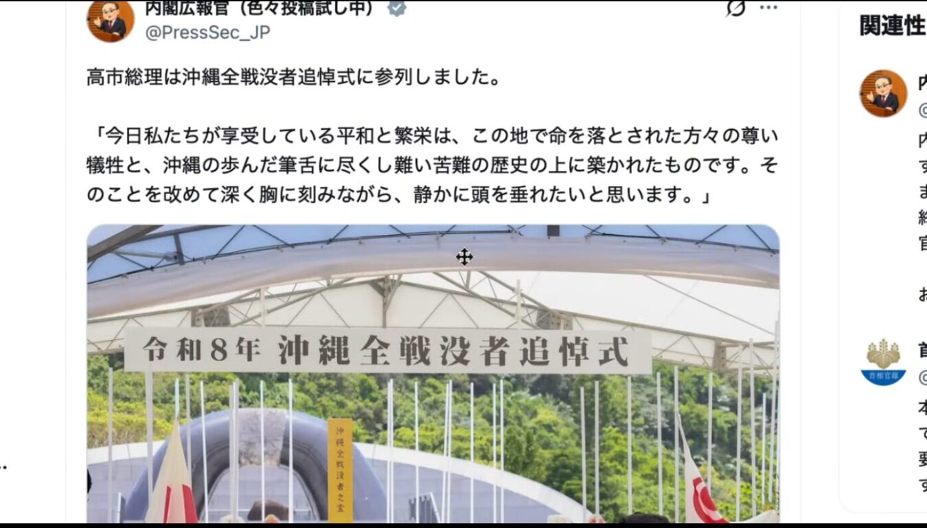 令和8年 沖縄全戦没者追悼式と書かれた横断幕が掲げられ、緑豊かな背景に式典会場の白い屋根が広がる様子。