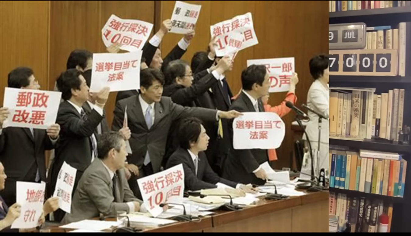 国会審議中にプラカードを掲げて抗議する複数の議員の様子