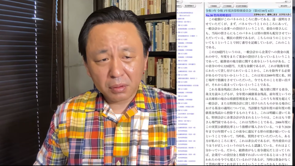 カラフルなチェック柄のシャツを着た菅野完が話し、画面右側に会議の議事録が表示されている。