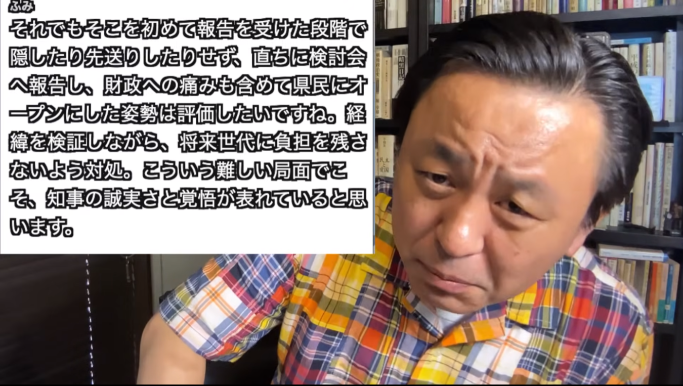 黄色のチェック柄のシャツを着た菅野完と、その横に日本語のテキストが表示されている様子