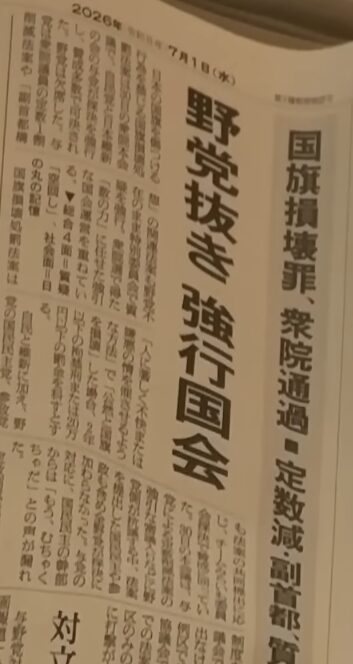 2026年7月1日の新聞記事で、野党が欠席する中で国旗損壊罪や定数減などの法案が強行採決された様子を報じている。