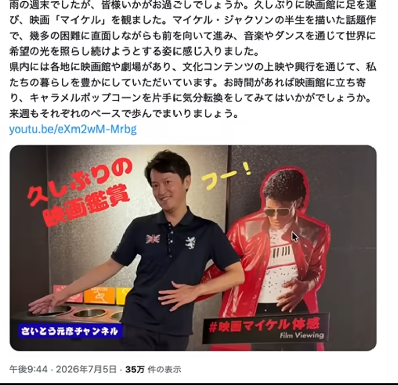 映画館でマイケル・ジャクソンの等身大パネルの横でポーズをとる男性の様子