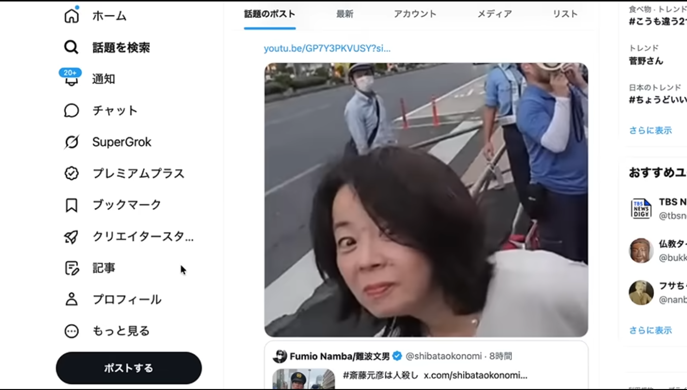 Xの投稿画面で、街頭でカメラに向かって表情を作る女性と、背後に立つ警察官や通行人が映る動画のスクリーンショット。