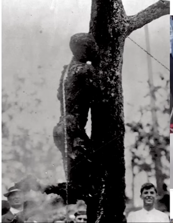 1916年にアメリカで発生したリンチ事件の記録写真。木に縛り付けられ焼かれた被害者の遺体と、それを取り囲む群衆の様子。