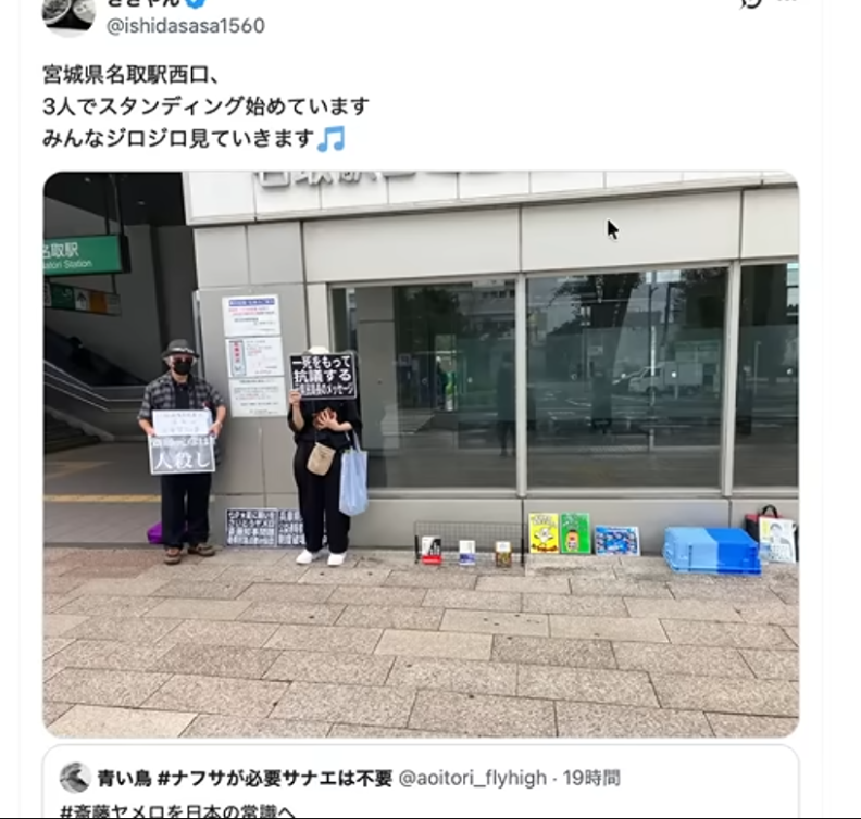宮城県の名取駅西口で、プラカードを持って立ち上がっている3人の様子。